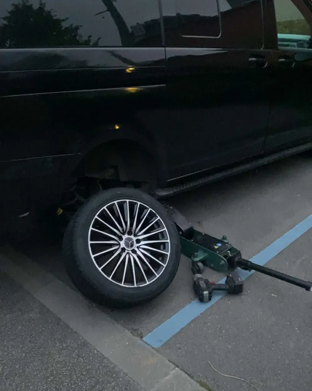 Réparation de pneu crevé sur place à Douai : véhicule sur cric et changement de roue en intervention mobile.